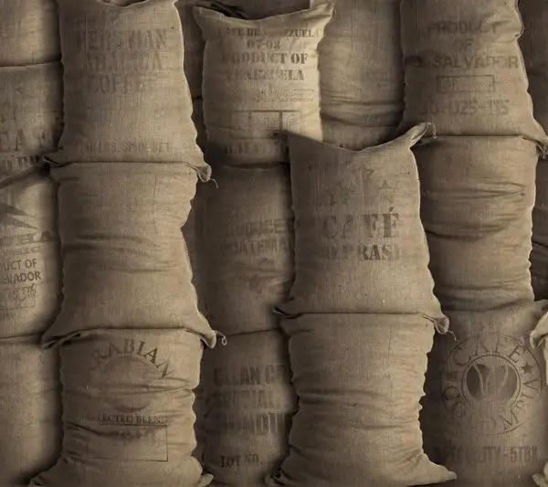 Üzerinde "Arabica Coffee" ve "Brasil" yazılı istiflenmiş jüt kahve çuvalları görünümlü duvar kağıdı.