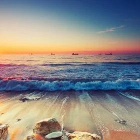 Gün batımı saati sahile vuran dalgalar ve kıyıdaki kayalıklar temalı 3D derinlik etkili duvar posteri.