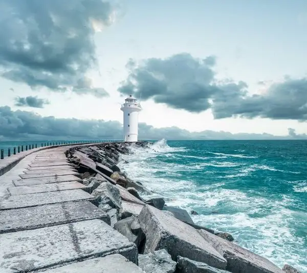 Kıyıya vuran beyaz köpüklü dalgalar ve tepedeki beyaz deniz feneri temalı 3D derinlik etkili deniz manzaralı duvar posteri.