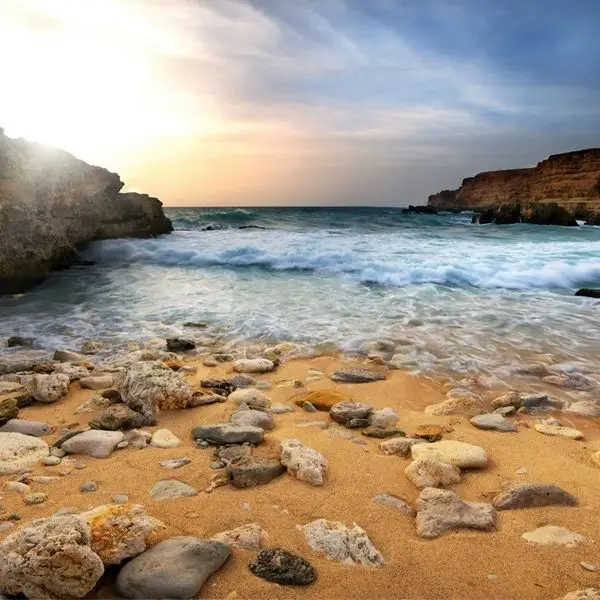 Gün batımında dalgalı deniz ve kayalık sahil manzaralı dekoratif doğa temalı duvar posteri.