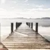 Sisler içinde sonsuzluk hissi veren ahşap iskele ve dingin göl manzaralı dijital baskı duvar posteri.