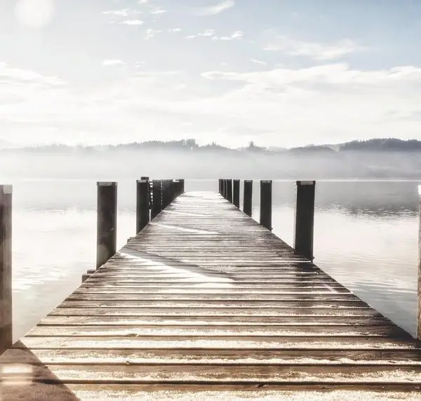 Sisler içinde sonsuzluk hissi veren ahşap iskele ve dingin göl manzaralı dijital baskı duvar posteri.